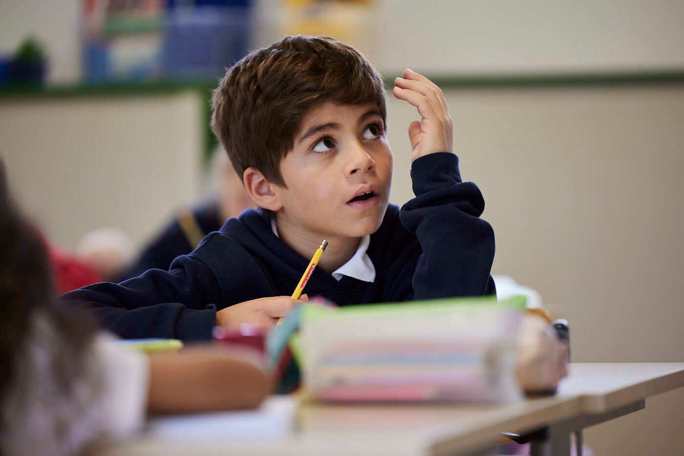 A boy student learns in a class, he is looking up.