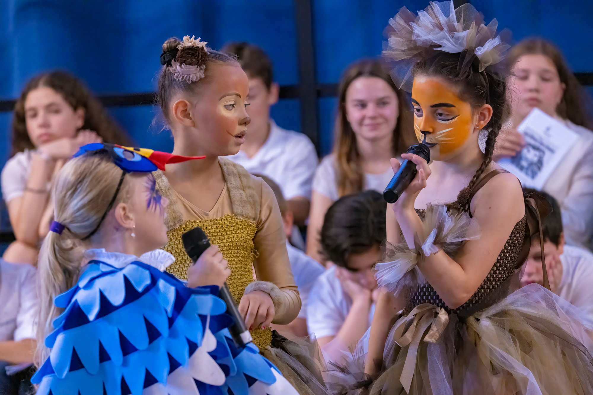 A goup of children in different colourful costumes perform a play