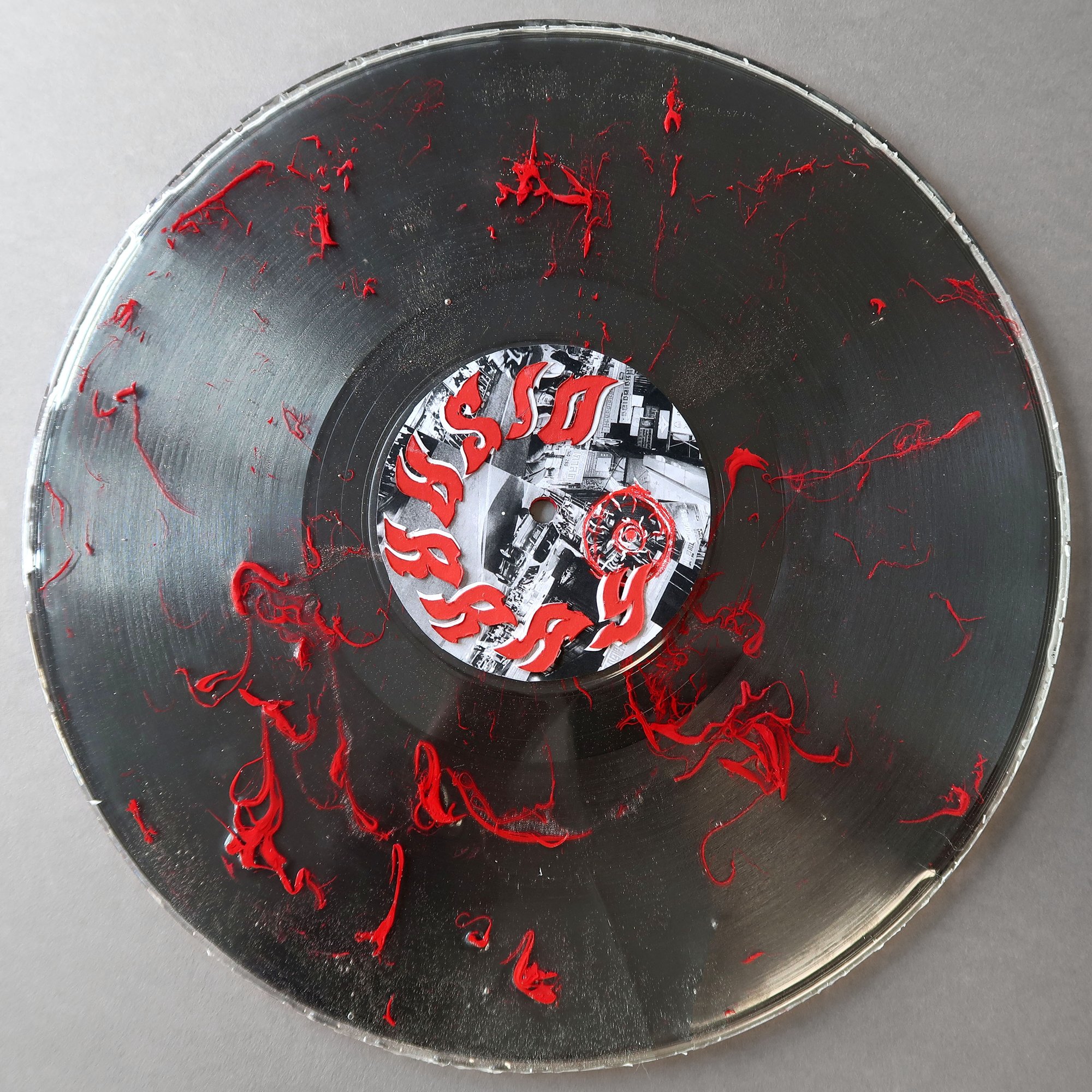 An art piece of a disc with red marks.