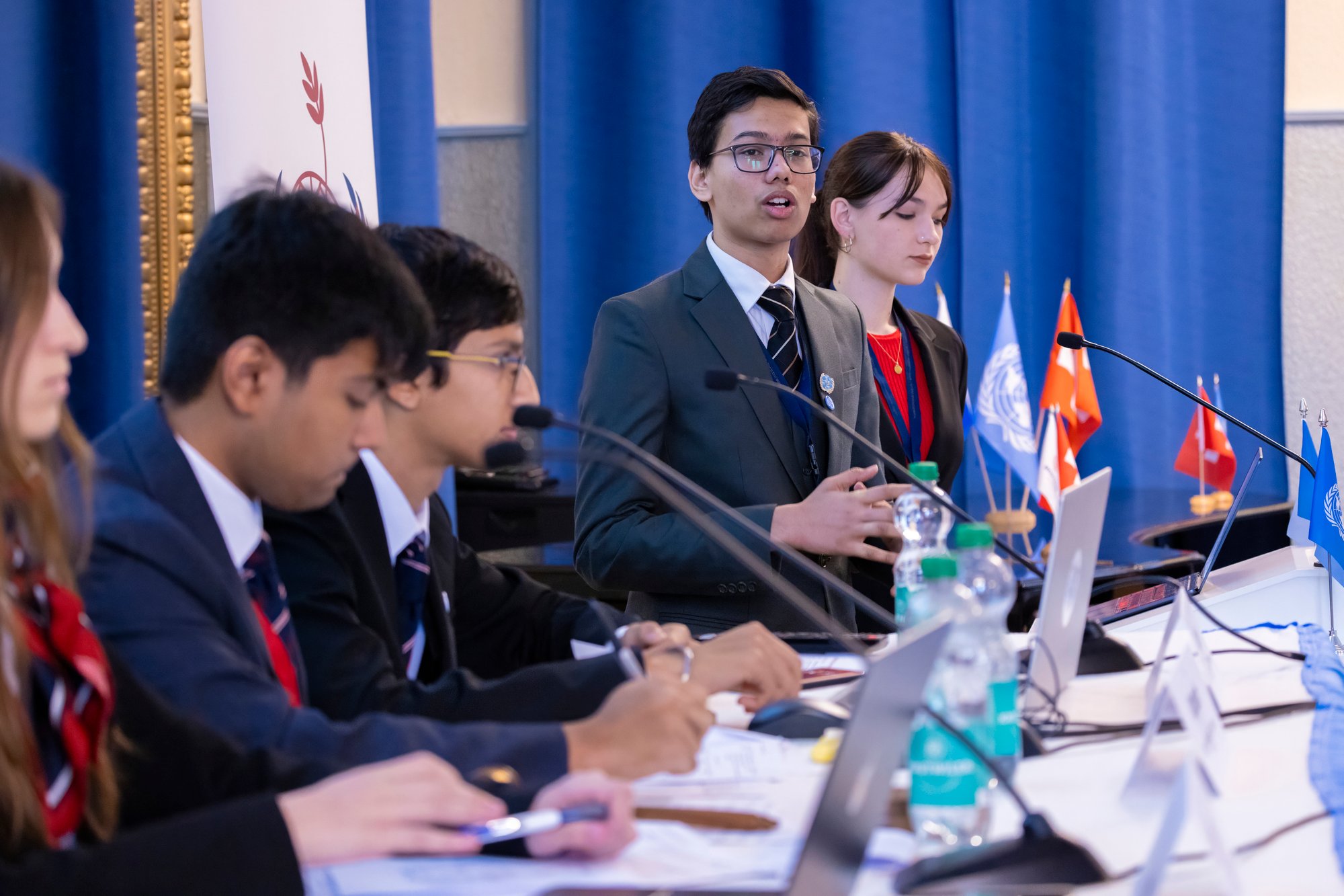 A male student stands up and speaks at a model united nations conference.