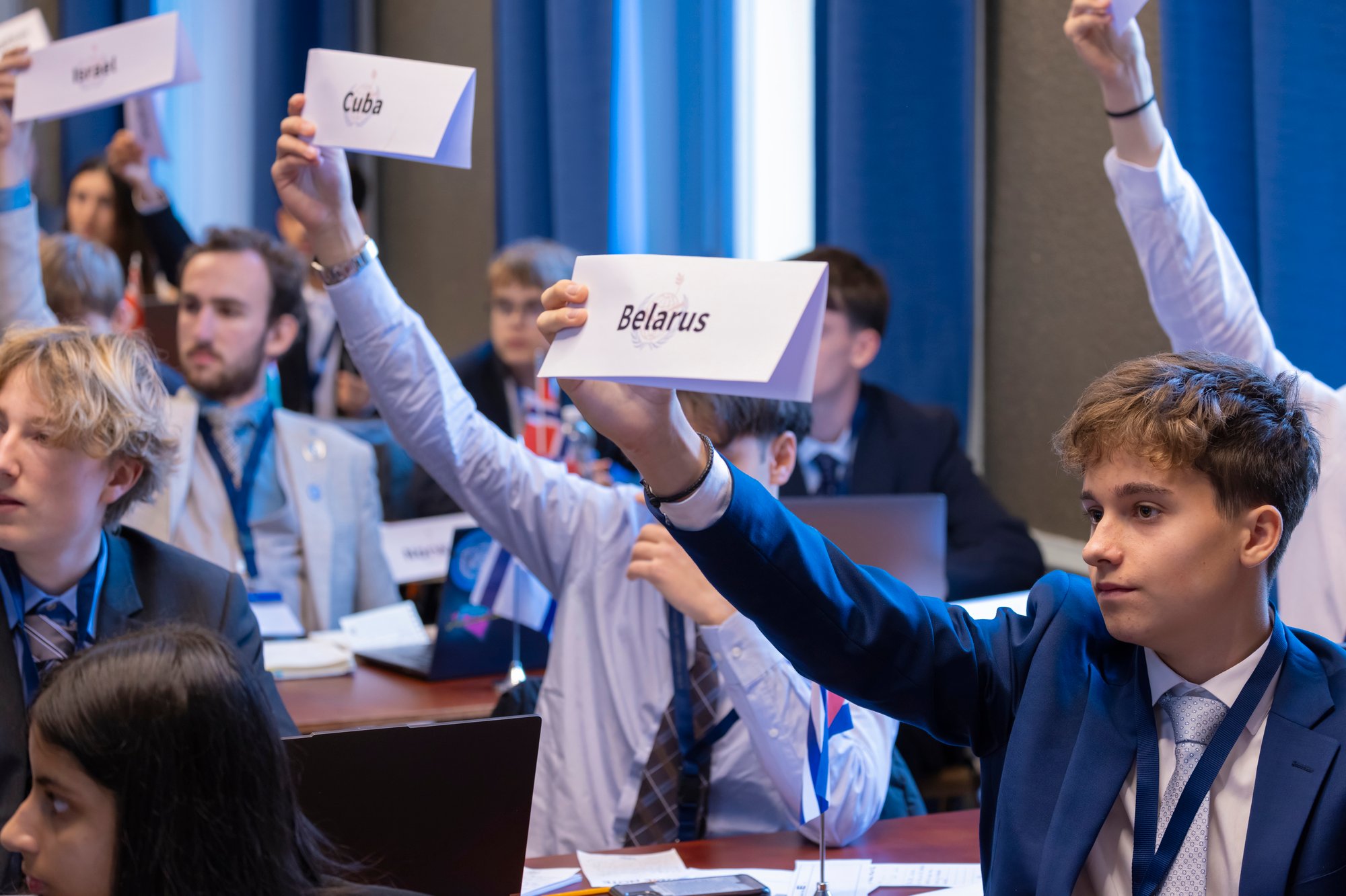 A group of students lift their delegates country signs.