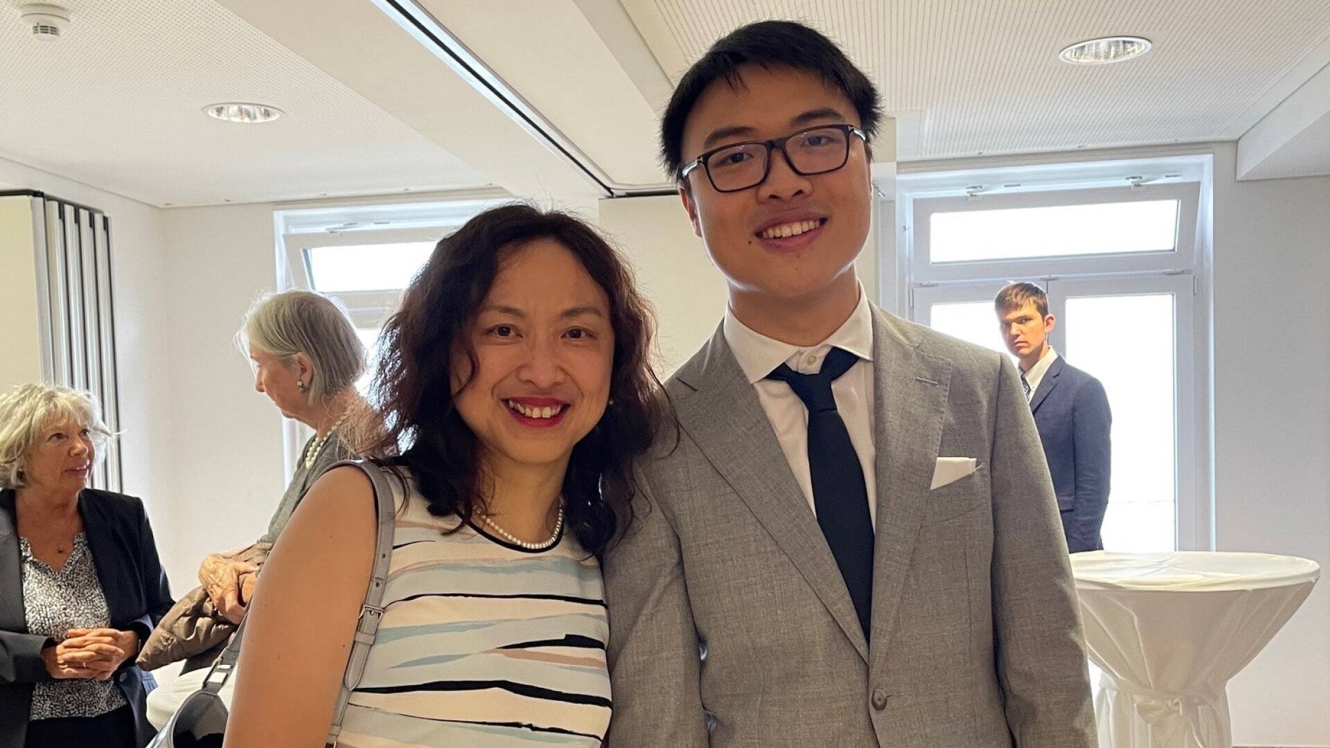 A mother and her son pose on his graduation.